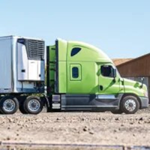 A lime green semi-truck parked in a dirt lot.